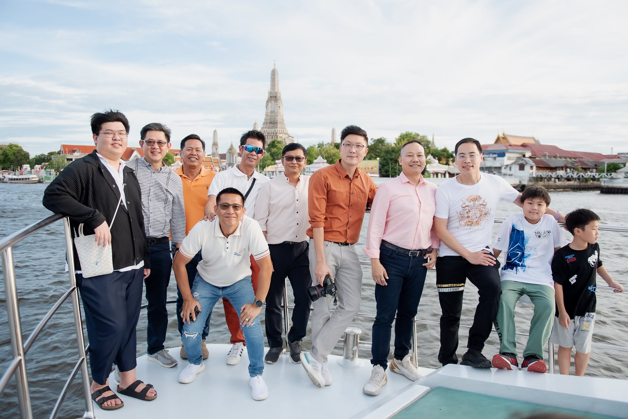 กลุ่มแขกจัดงานบนดาดฟ้าเรือโดยมีวัดอรุณอยู่ด้านหลัง